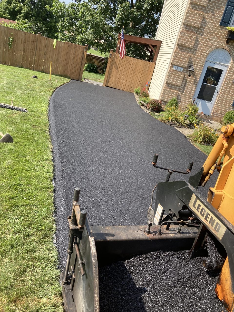 Close-up of the paver screed laying hot asphalt
